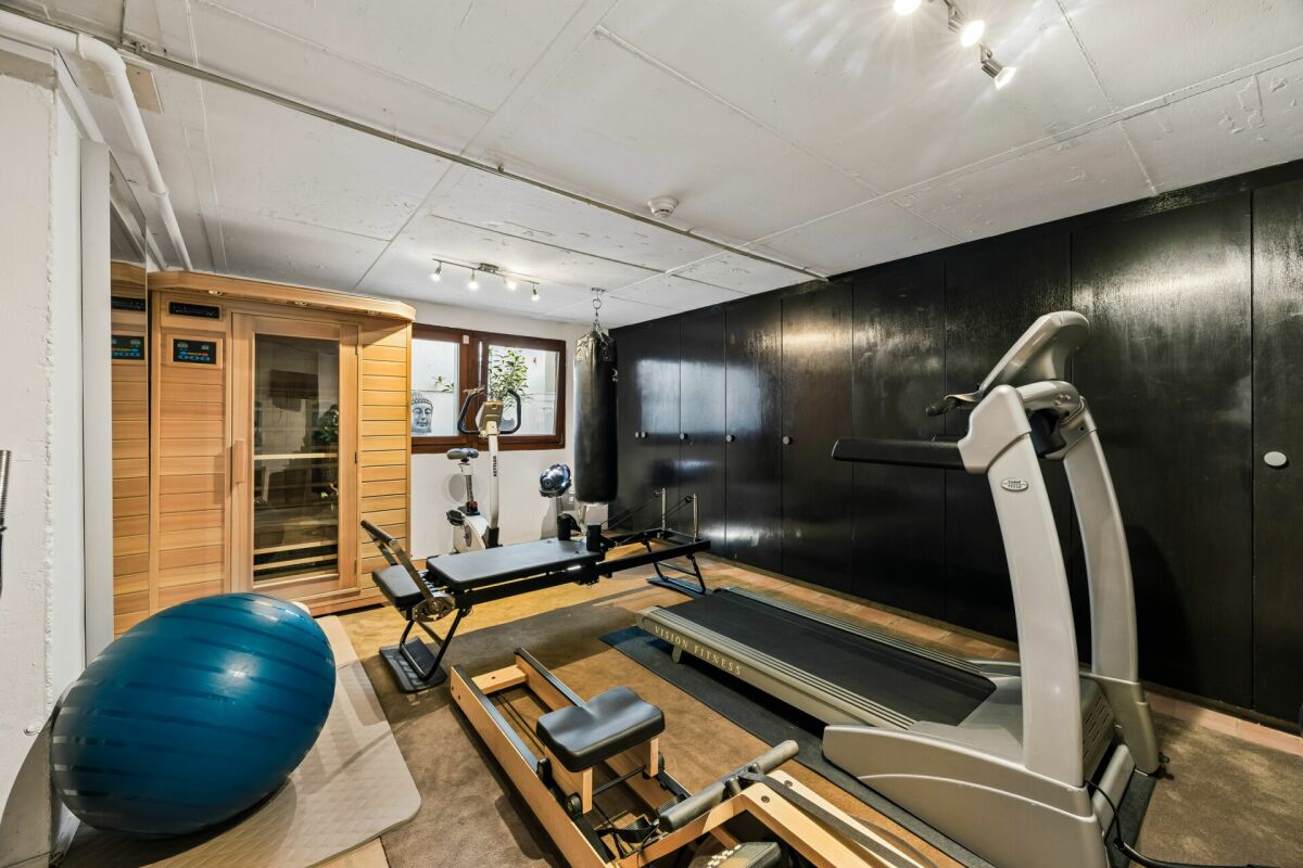 Keller-Fitnessraum mit Trainingsgeräten und Sauna