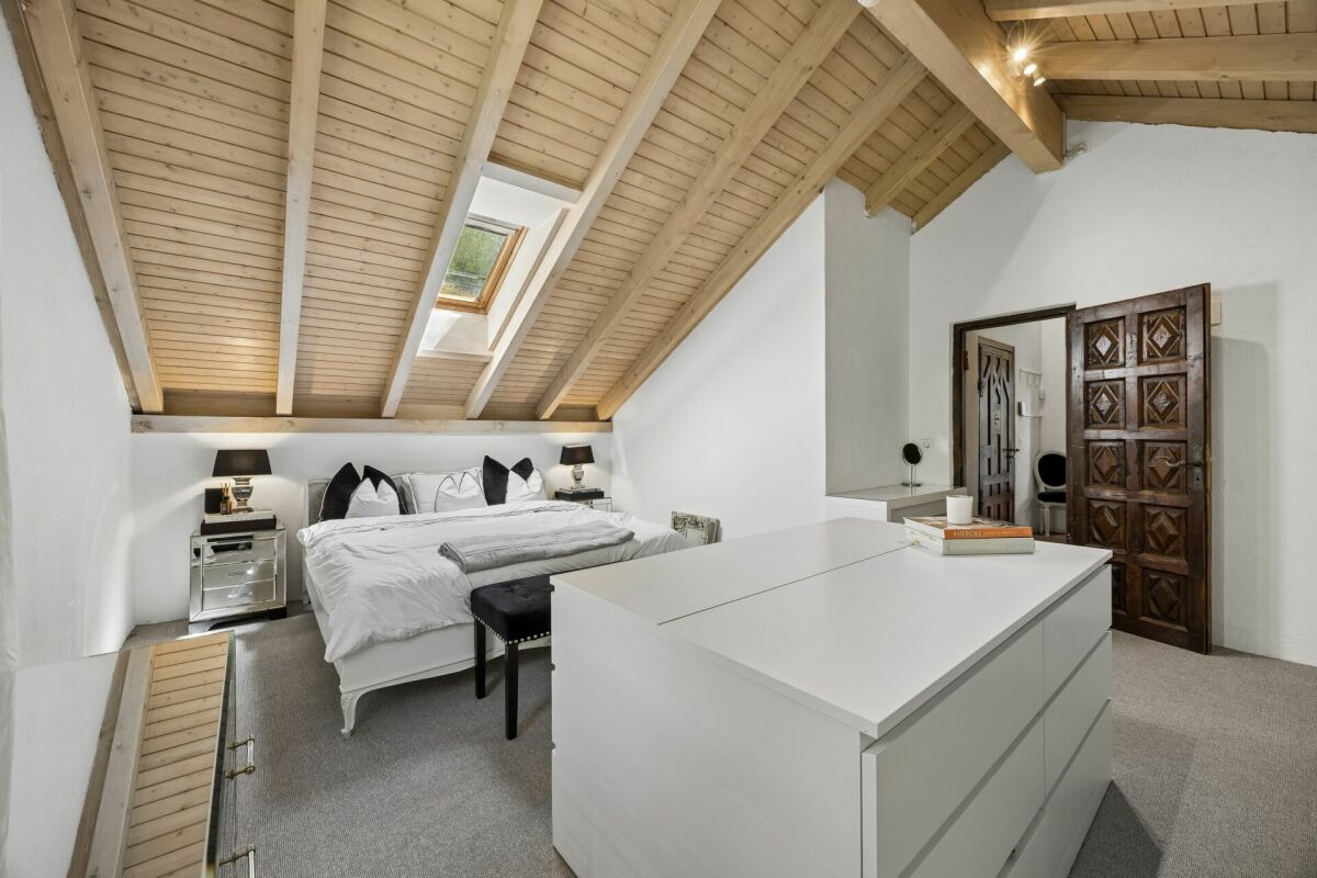 Dachgeschoss-Schlafzimmer mit sichtbaren Holzbalken