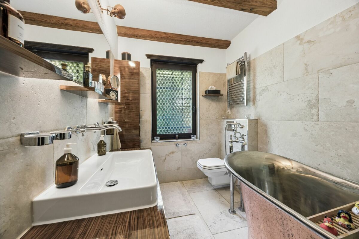 Badezimmer mit Naturstein und Holzdetails