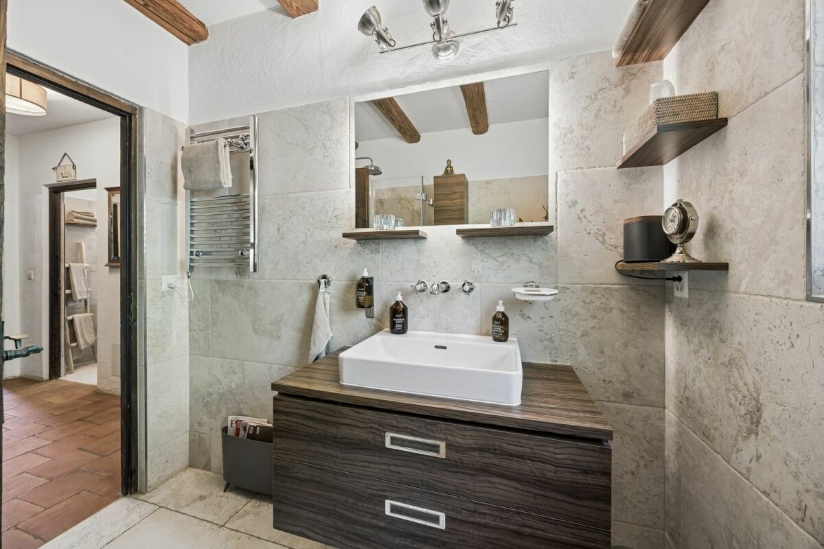 Modernes Badezimmer mit Naturstein und Holzwaschtisch
