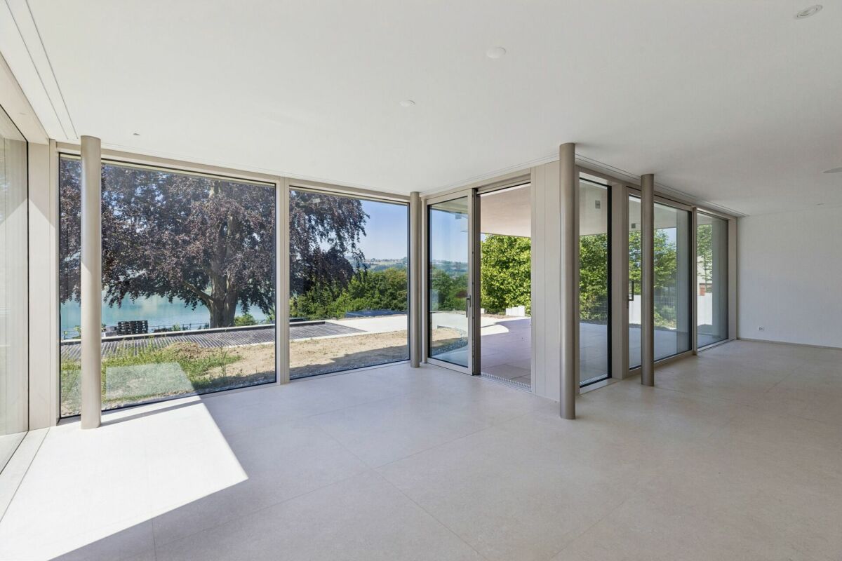 Großer leerer Wohnraum mit Panorama-Glasfront