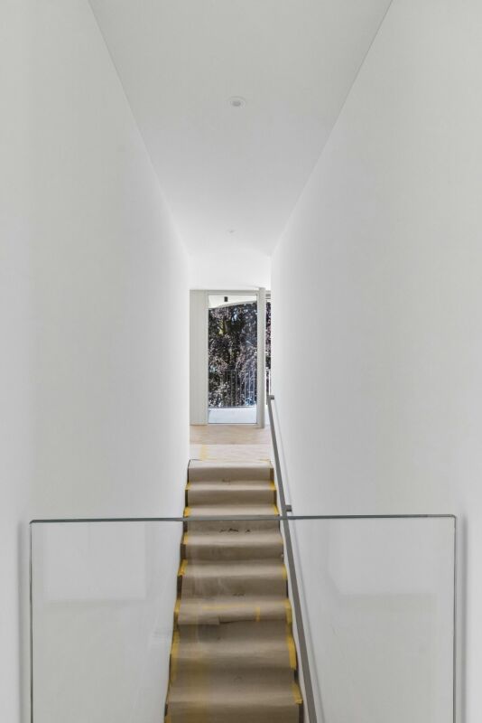 Heller Flur mit Treppe und Glasgeländer