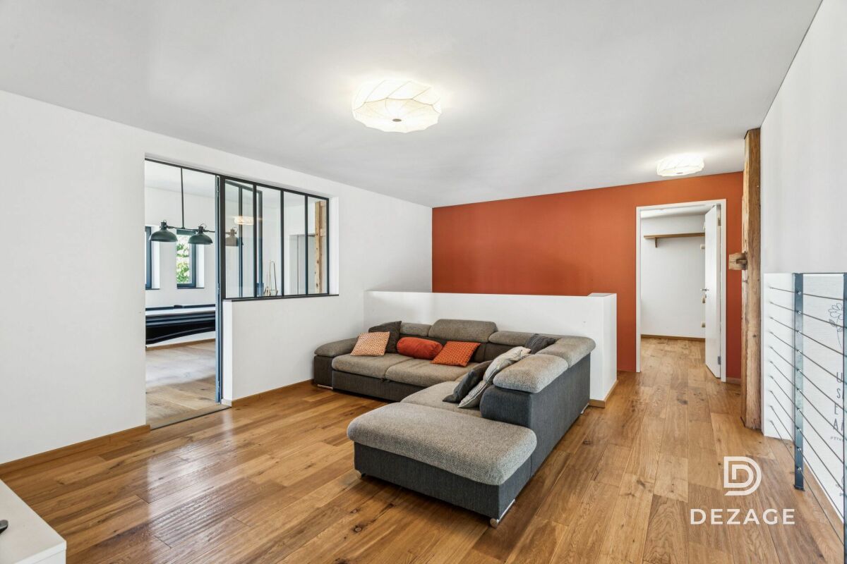 Heller Wohnraum mit Holzboden und orangefarbener Akzentwand