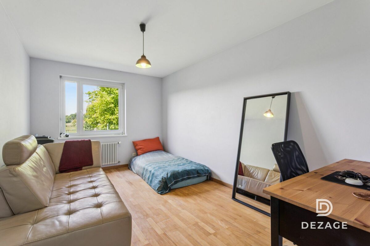 Helles Schlafzimmer mit Einzelbett und Sofa