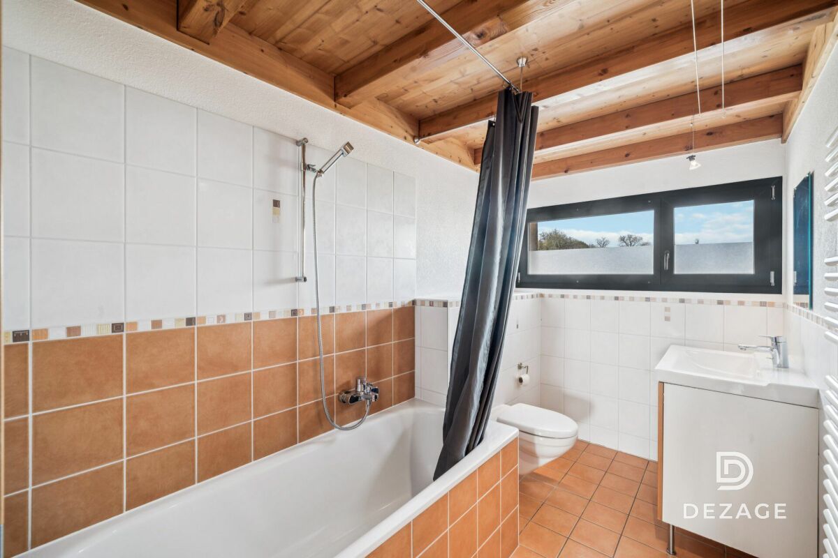 Modernes Badezimmer mit Badewanne und Dachbalken