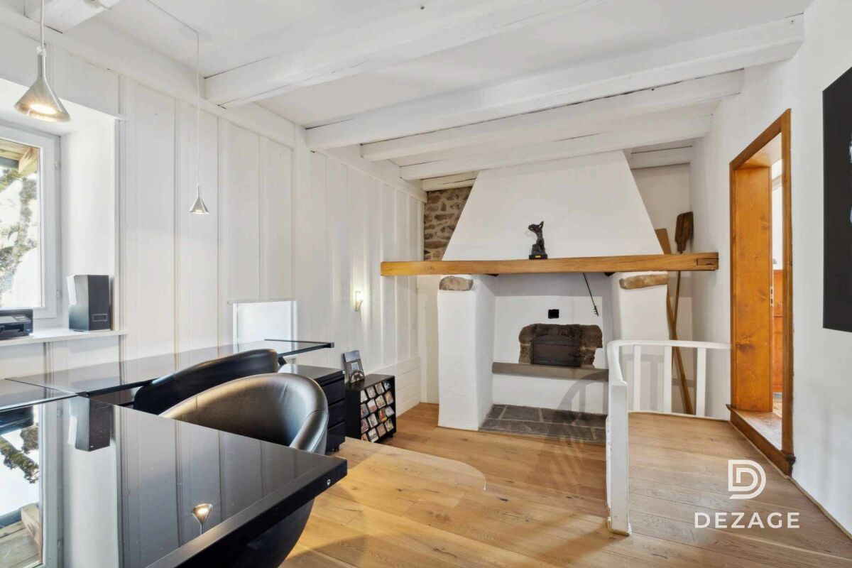 Wohnraum mit Kamin und sichtbaren Holzbalken