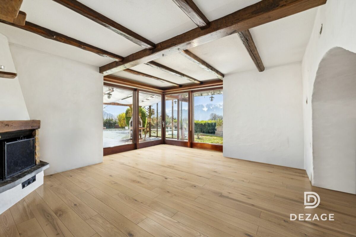 Wohnraum mit sichtbaren Holzbalken und Panoramafenstern