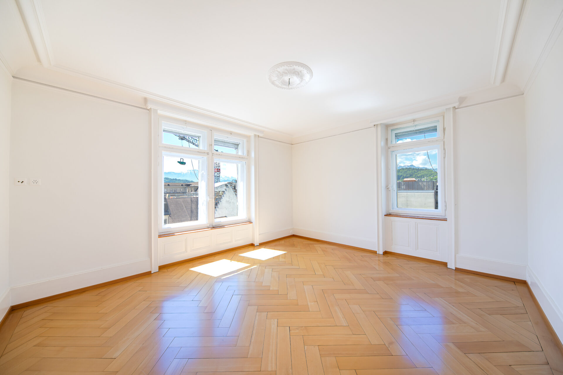 Heller leerer Altbau-Raum mit Fischgrätparkett