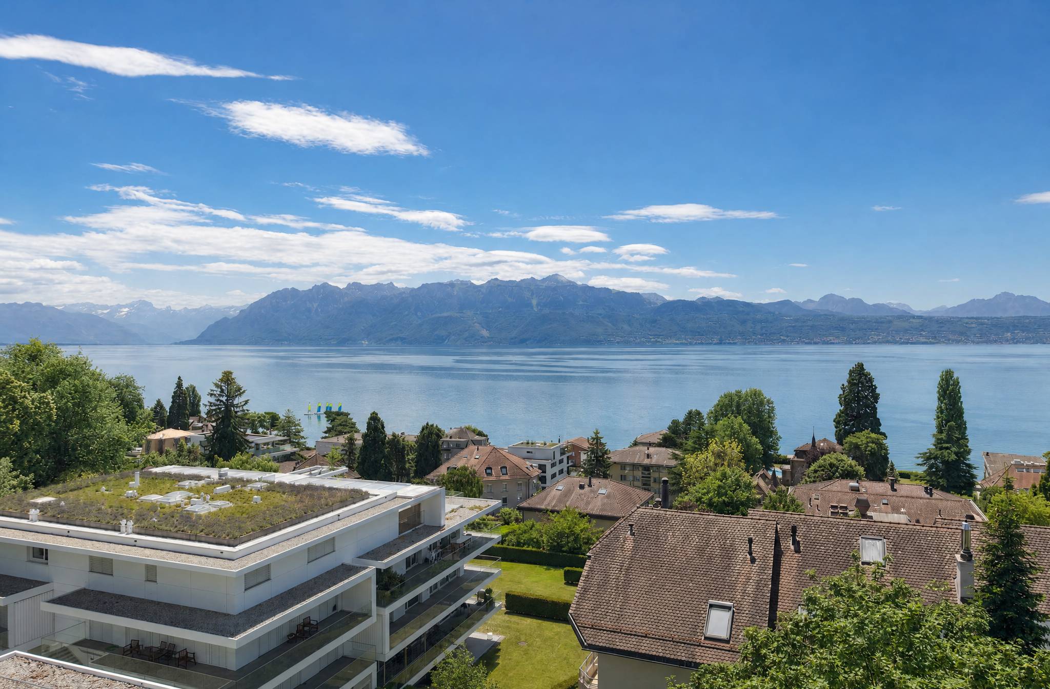 Seeblick mit Bergen und Wohngebäuden
