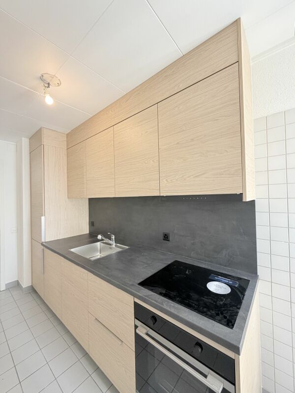 Moderne helle Küche mit Holzfronten und dunkler Arbeitsfläche