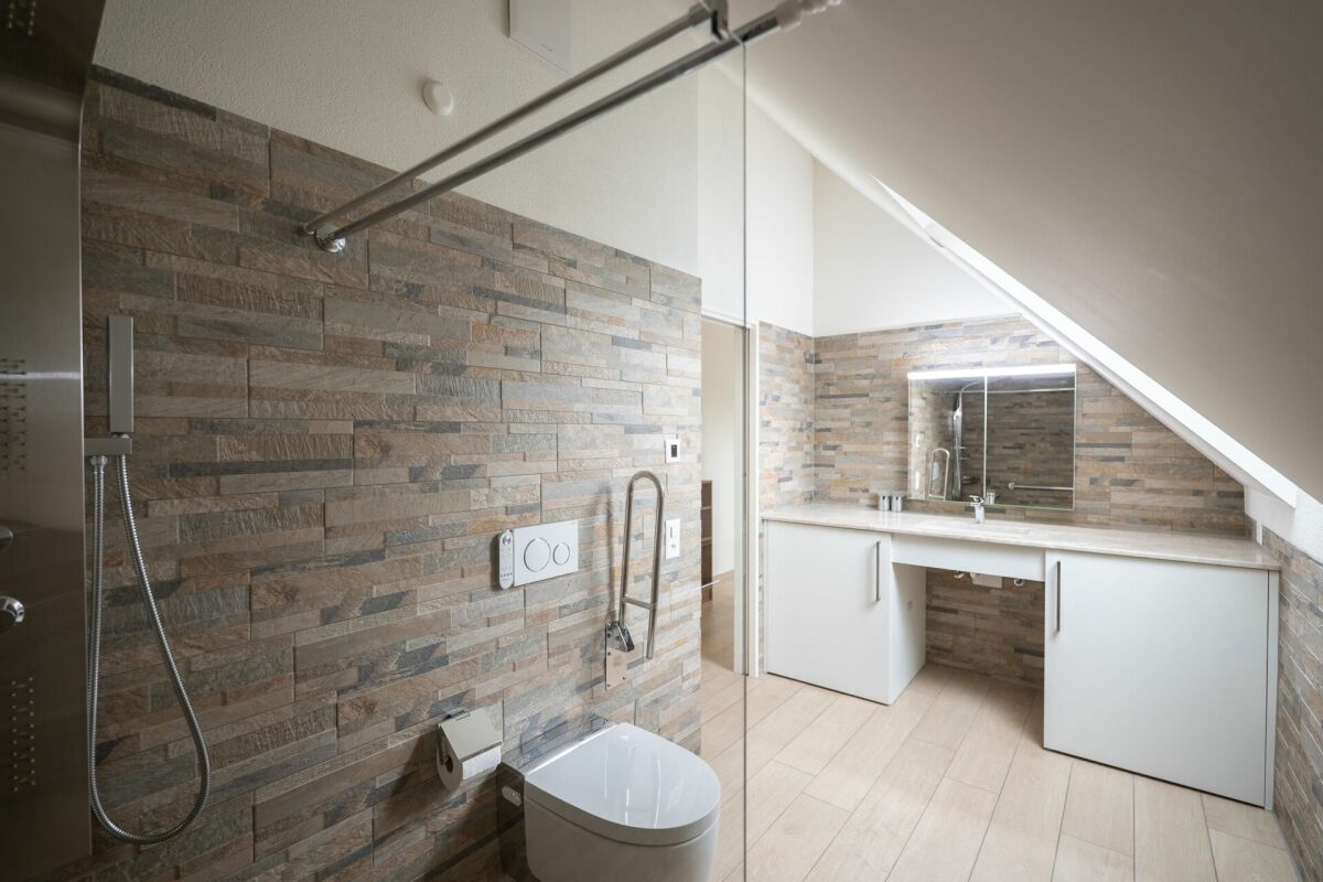 Modernes Dachgeschoss-Badezimmer mit Steinoptik und Waschtisch