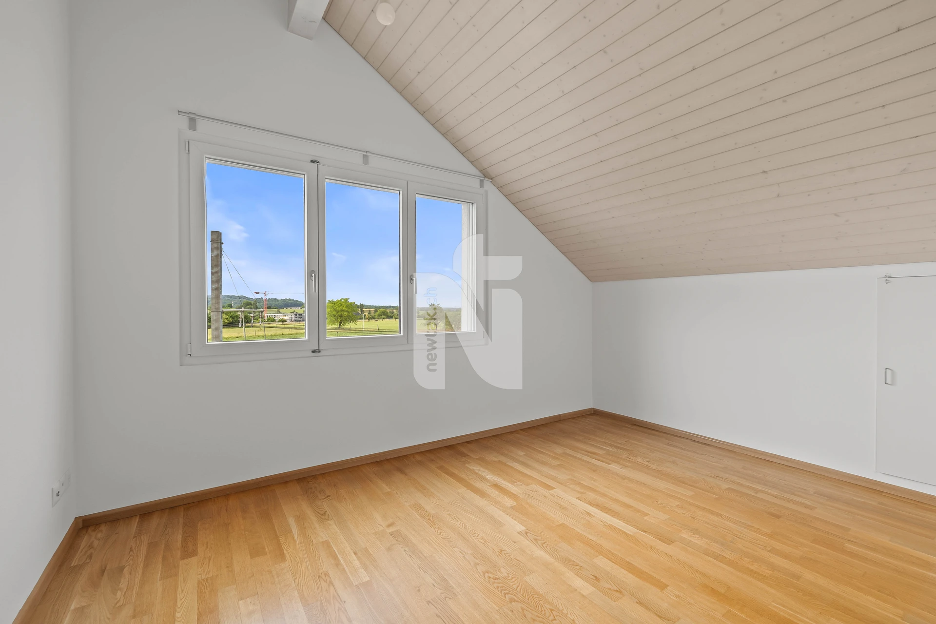 Leerer Dachraum mit Parkettboden und Dachschräge