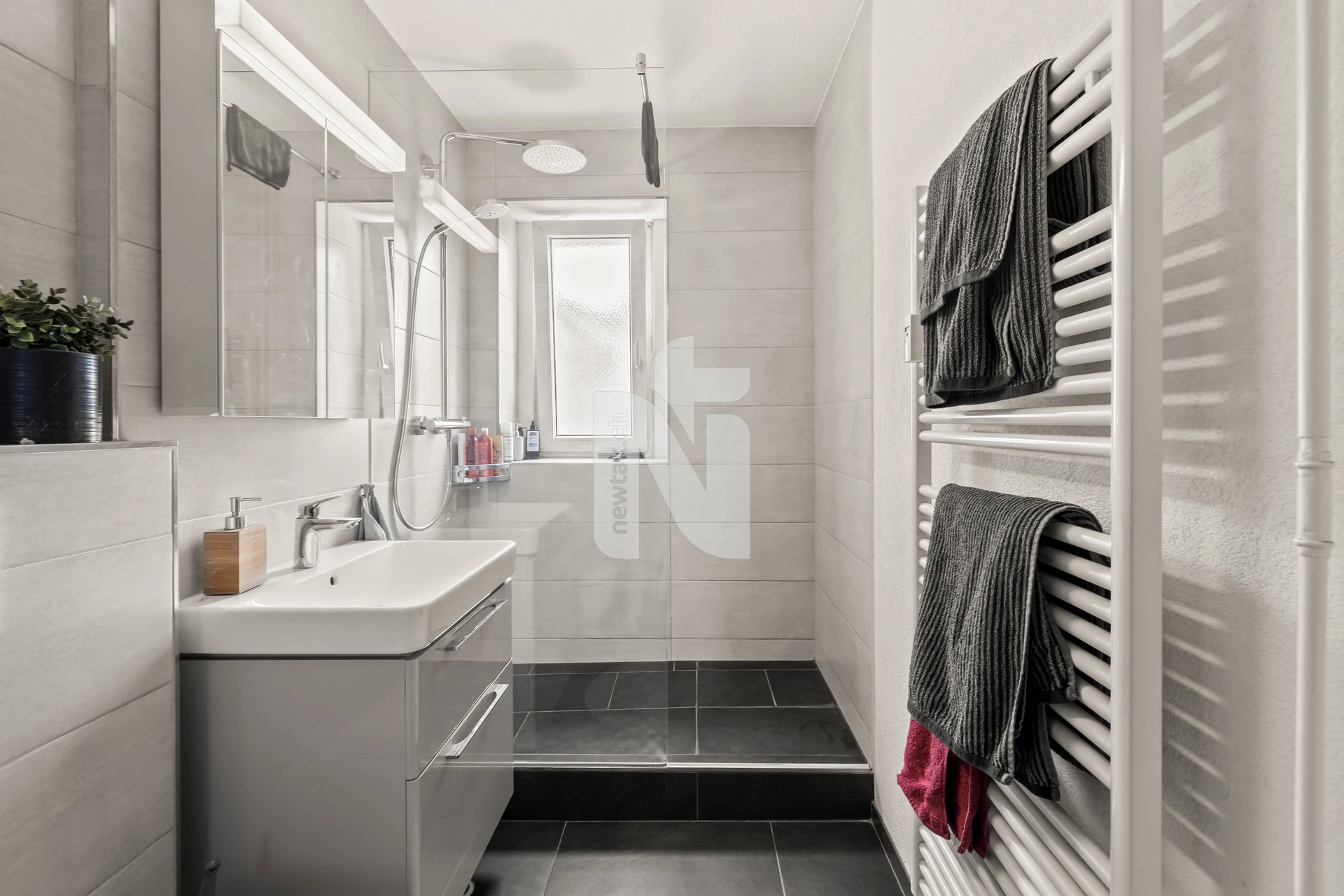 Modernes, helles Badezimmer mit Dusche und Waschtisch