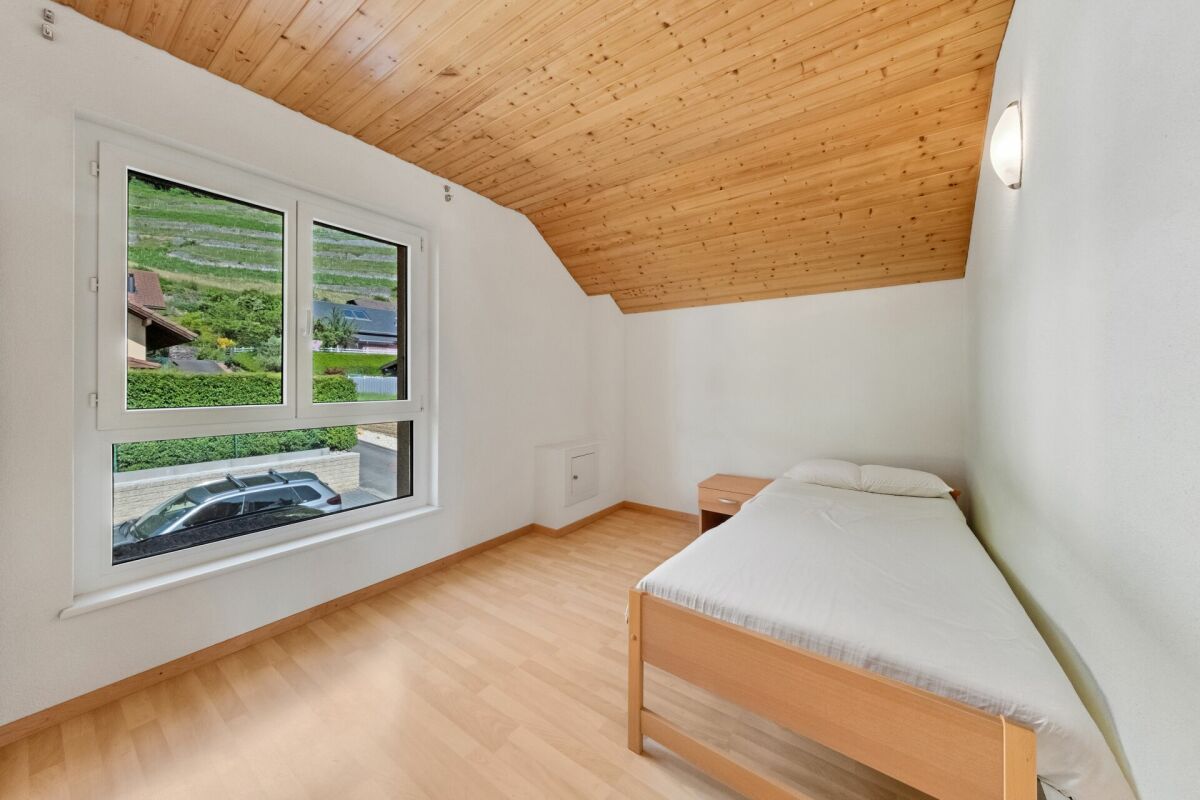 Kleines Dachgeschoss-Schlafzimmer mit großem Fenster
