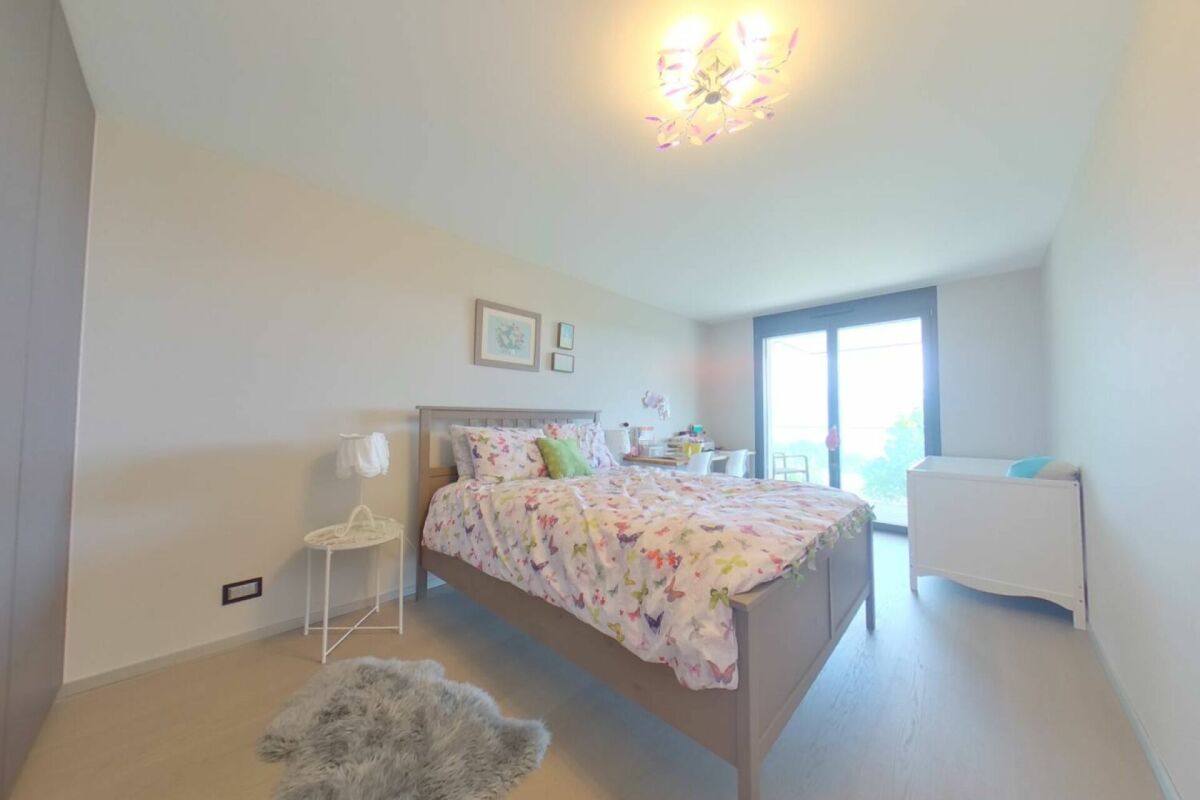 Helles Schlafzimmer mit Flügeltür zum Balkon