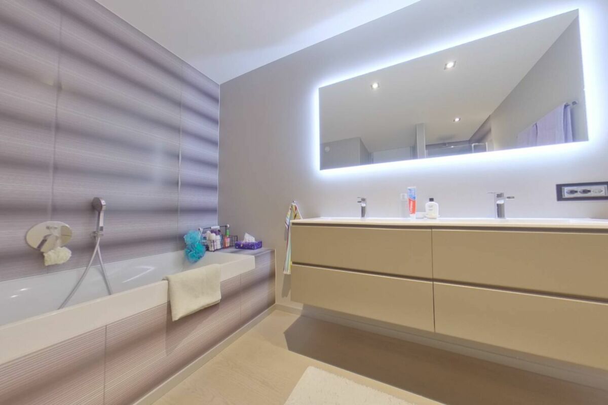 Modernes Badezimmer mit LED-Spiegel und Wanne