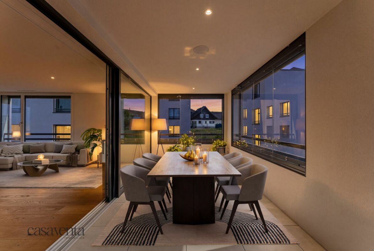 Essbereich auf einer verglasten Loggia mit Blick ins Abendlicht