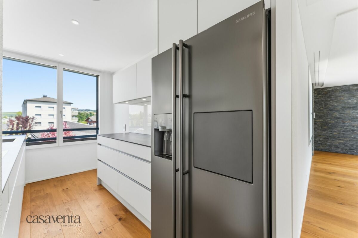 Moderne Küche mit großem Fenster und Edelstahl-Kühlschrank