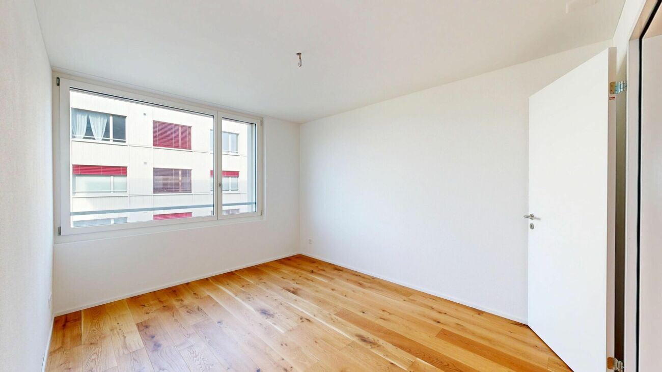 Helles, leeres Zimmer mit Parkettboden
