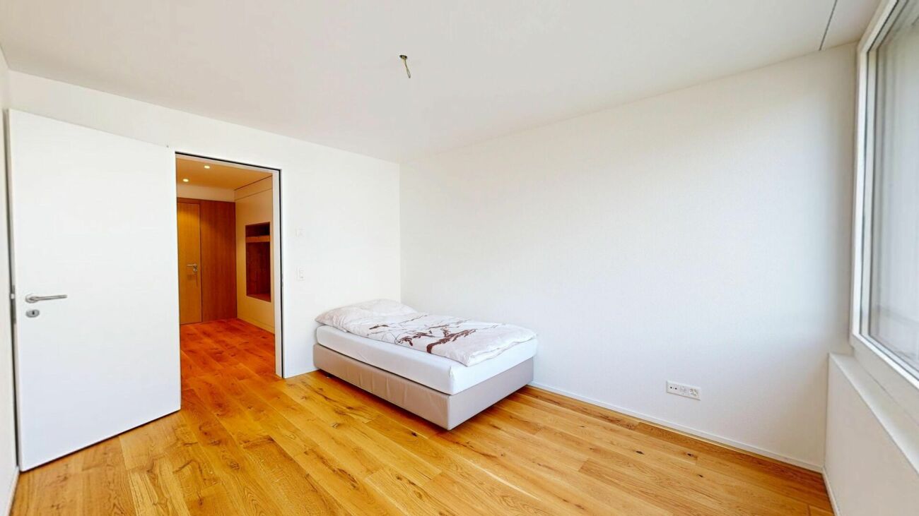 Helles Schlafzimmer mit Bett und Holzfußboden