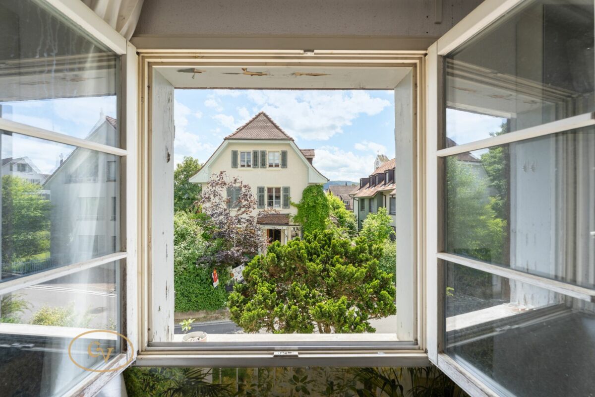 Fensterblick auf Wohnhaus mit Garten und Nachbargebäuden