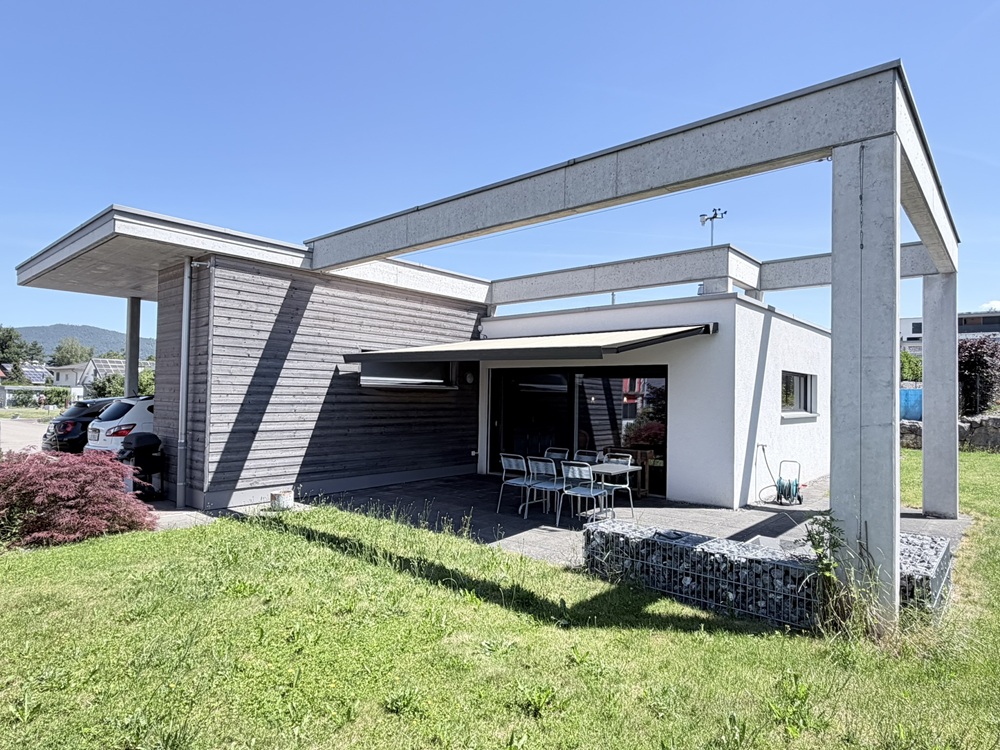 Moderne Außenansicht mit Terrasse und Carport
