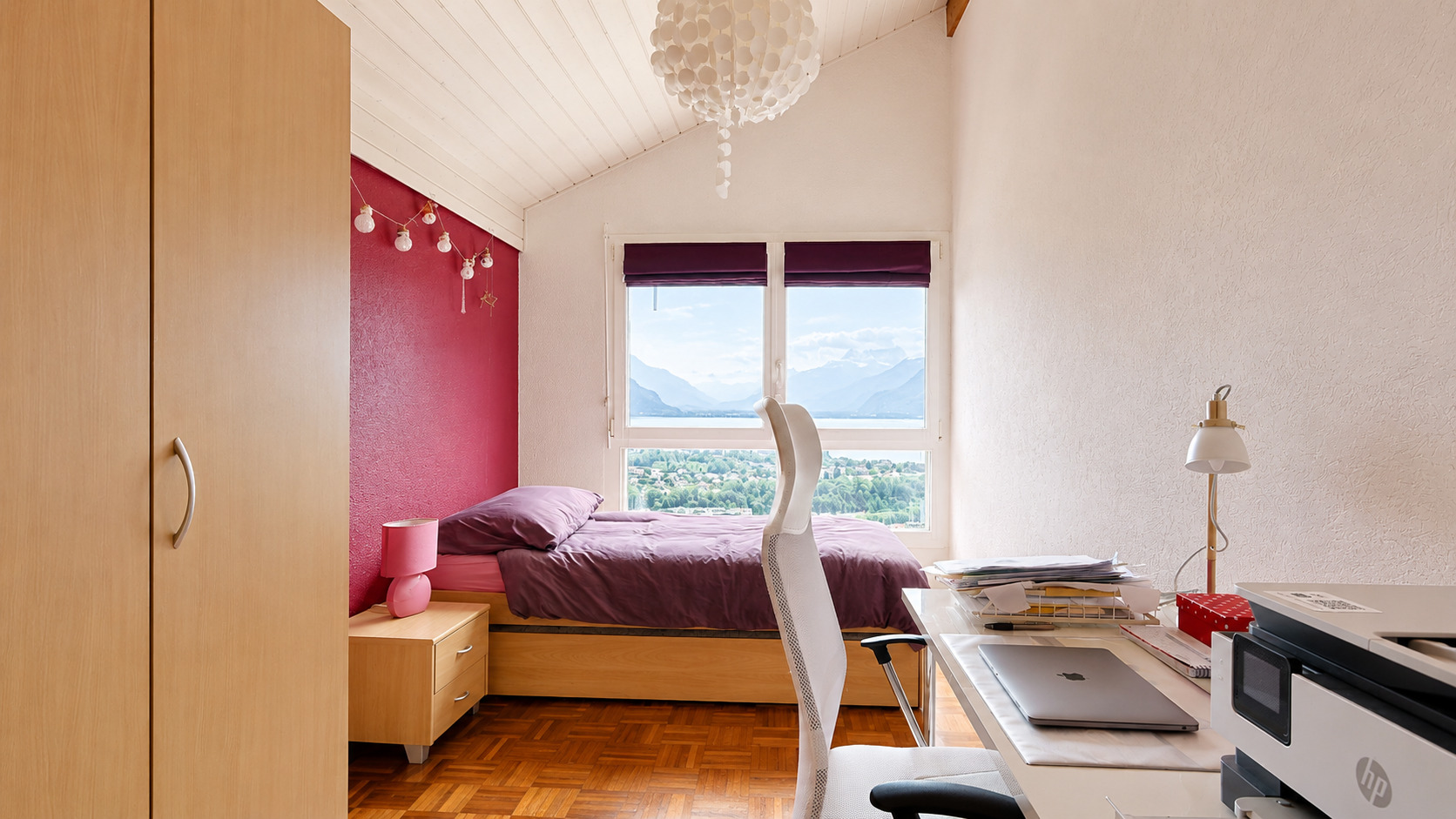 Helles Schlafzimmer mit Arbeitsplatz und Bergblick