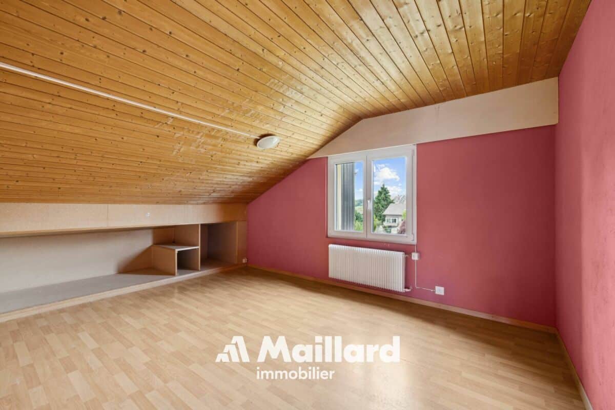 Dachzimmer mit Holzdecke und rosa Wänden