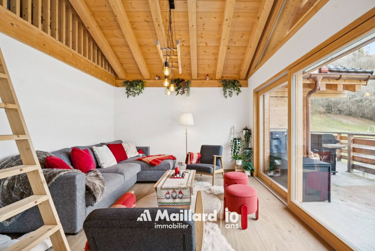 Gemütlicher Wohnraum mit Holzdecke und Balkonzugang