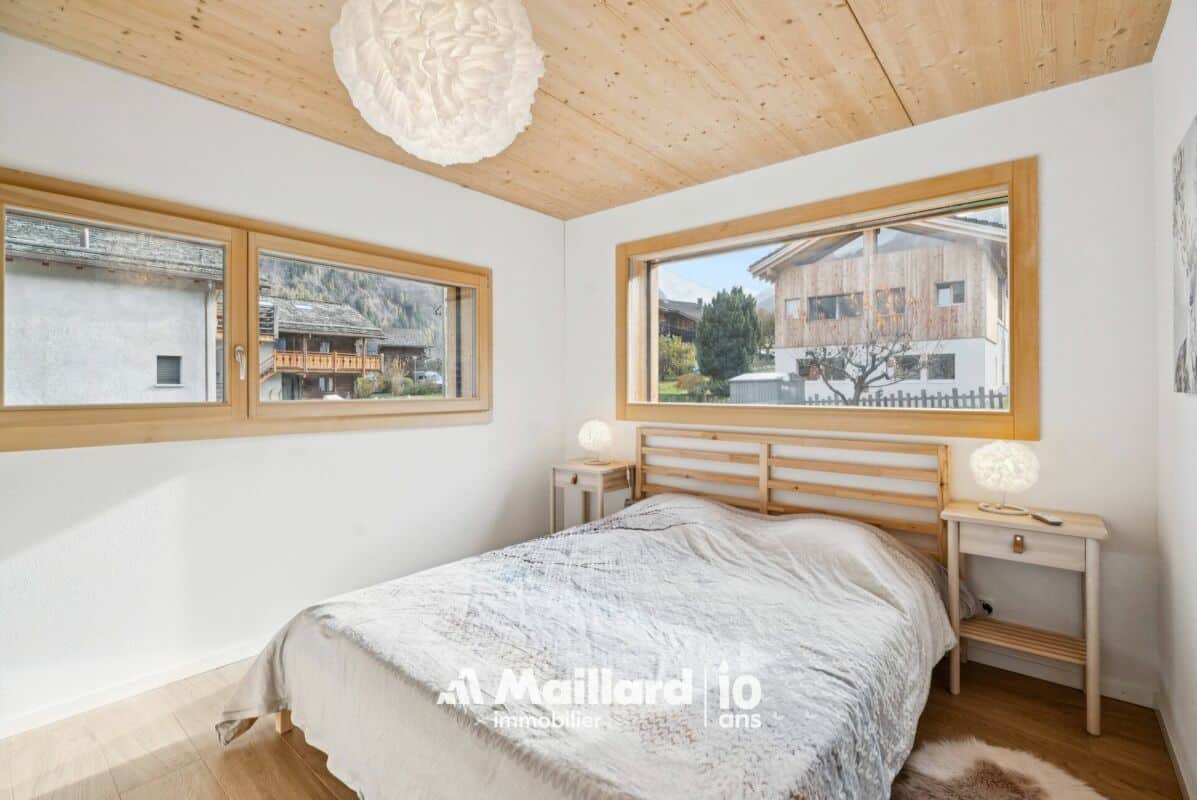 Helles Schlafzimmer mit großen Holzfenstern