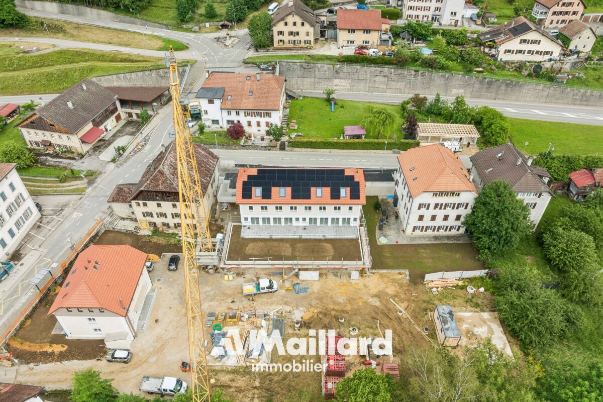 Luftaufnahme eines Wohn- und Bauareals mit Neubau und Kran