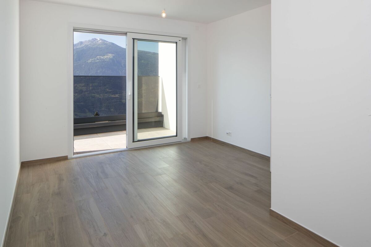 Heller leerer Raum mit Balkon und Bergblick