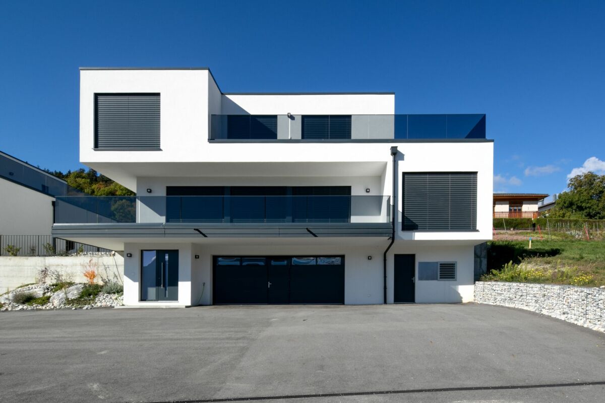 Moderne weiße Villa mit Flachdach und großen Balkonen