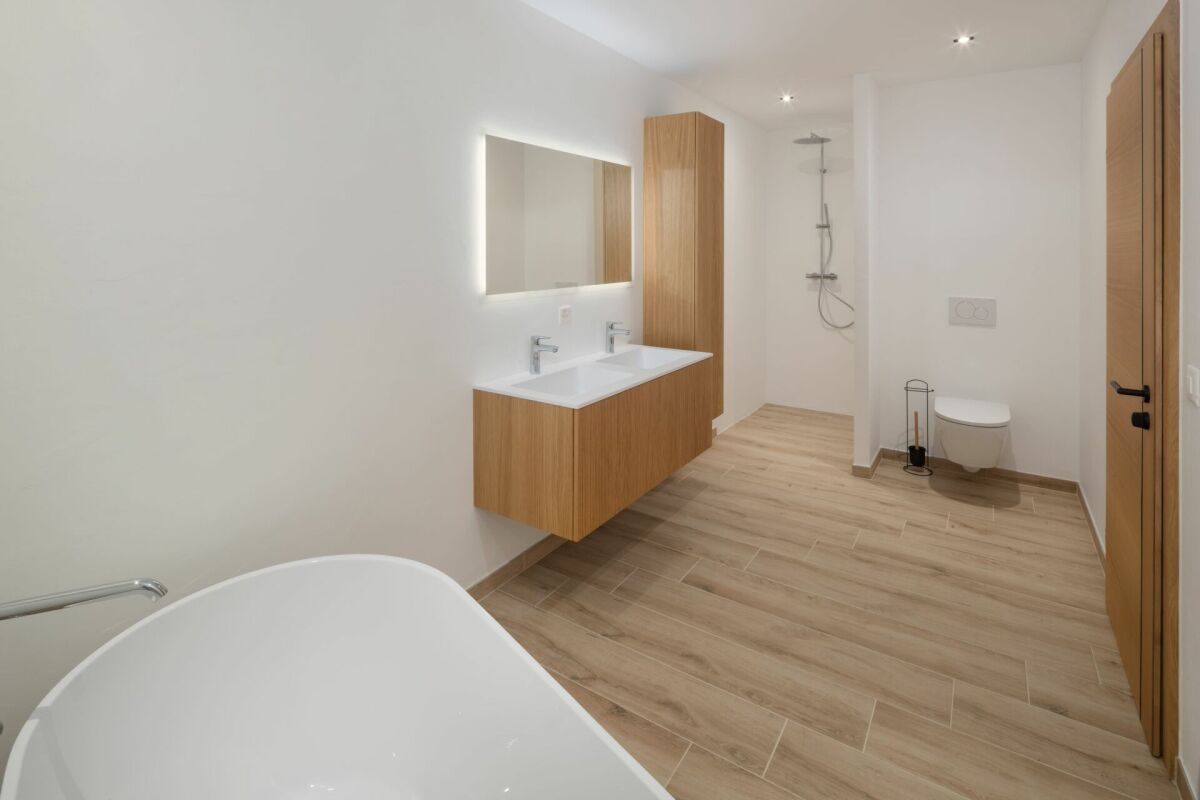 Modernes Badezimmer mit Holzoptik und Badewanne