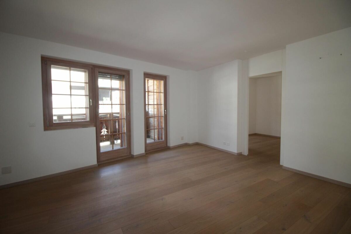 Leerer Wohnraum mit Holzboden und Fenstertür