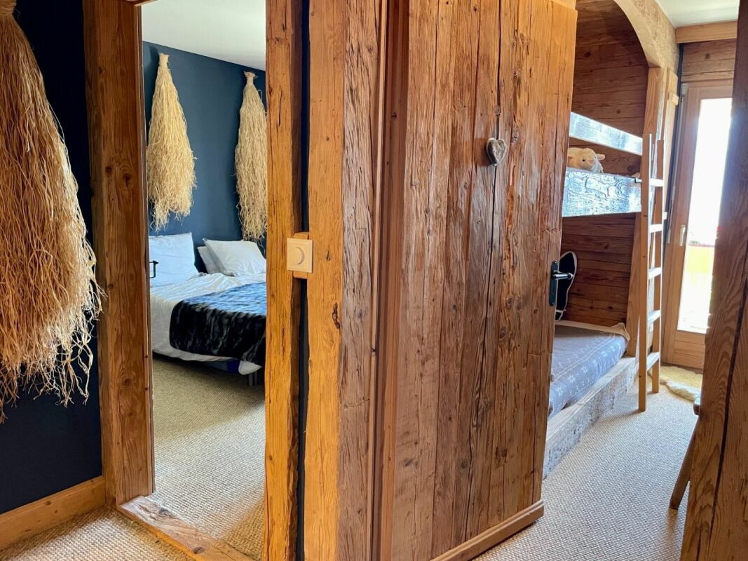 Rustikal gestaltetes Schlafzimmer mit Holzvertäfelung und Hochbett