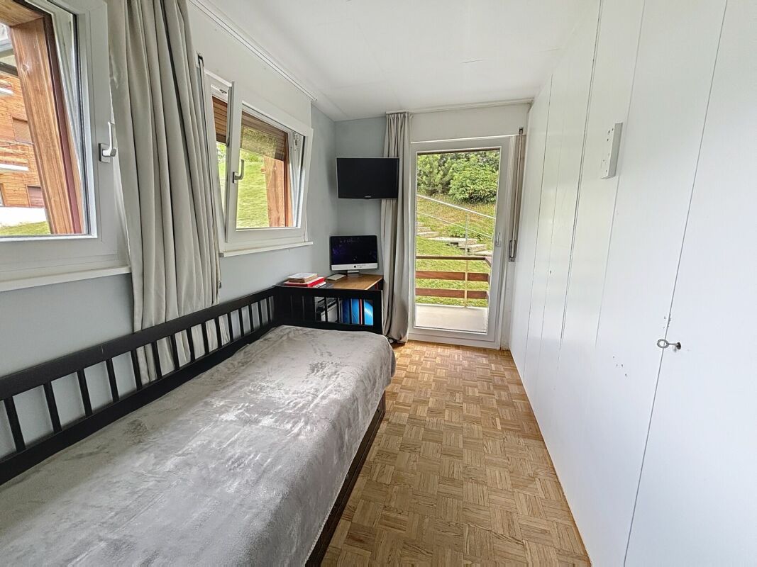 Schmales Schlafzimmer mit Einzelbett und Balkonzugang