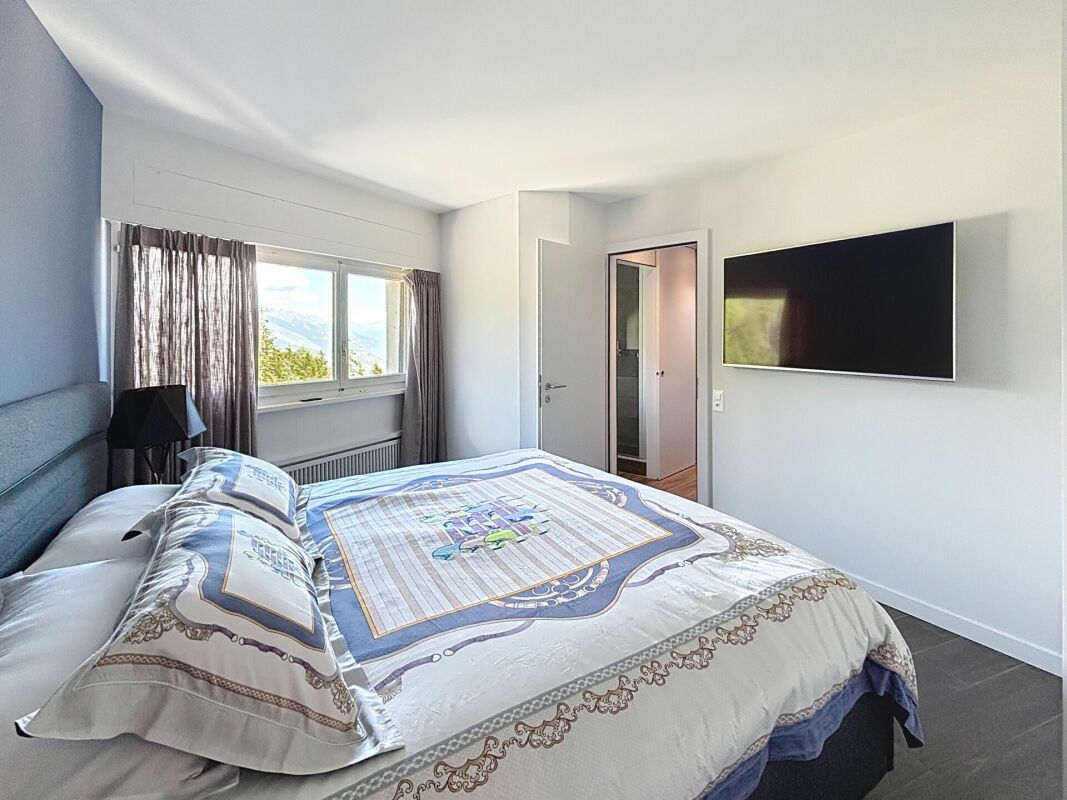 Modernes Schlafzimmer mit TV und Blick ins Freie