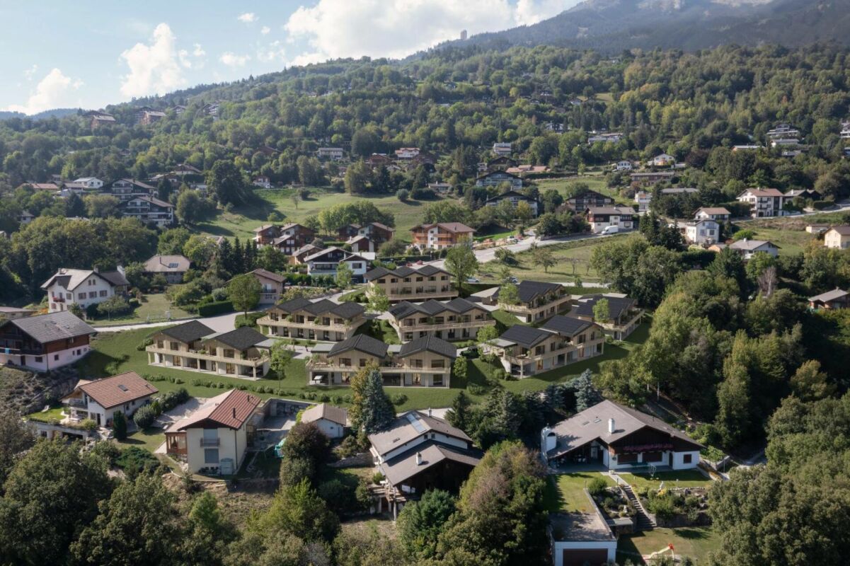 Luftaufnahme einer grünen Hanglage mit Wohnsiedlung