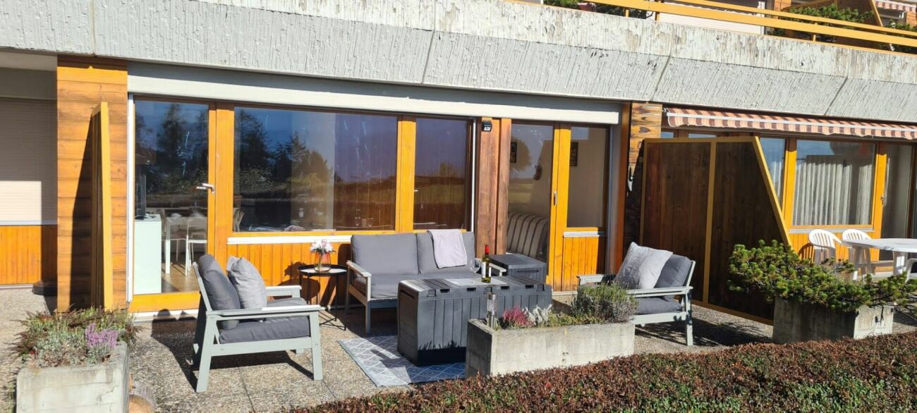 Terrasse mit Sitzgruppe vor Holzfassade