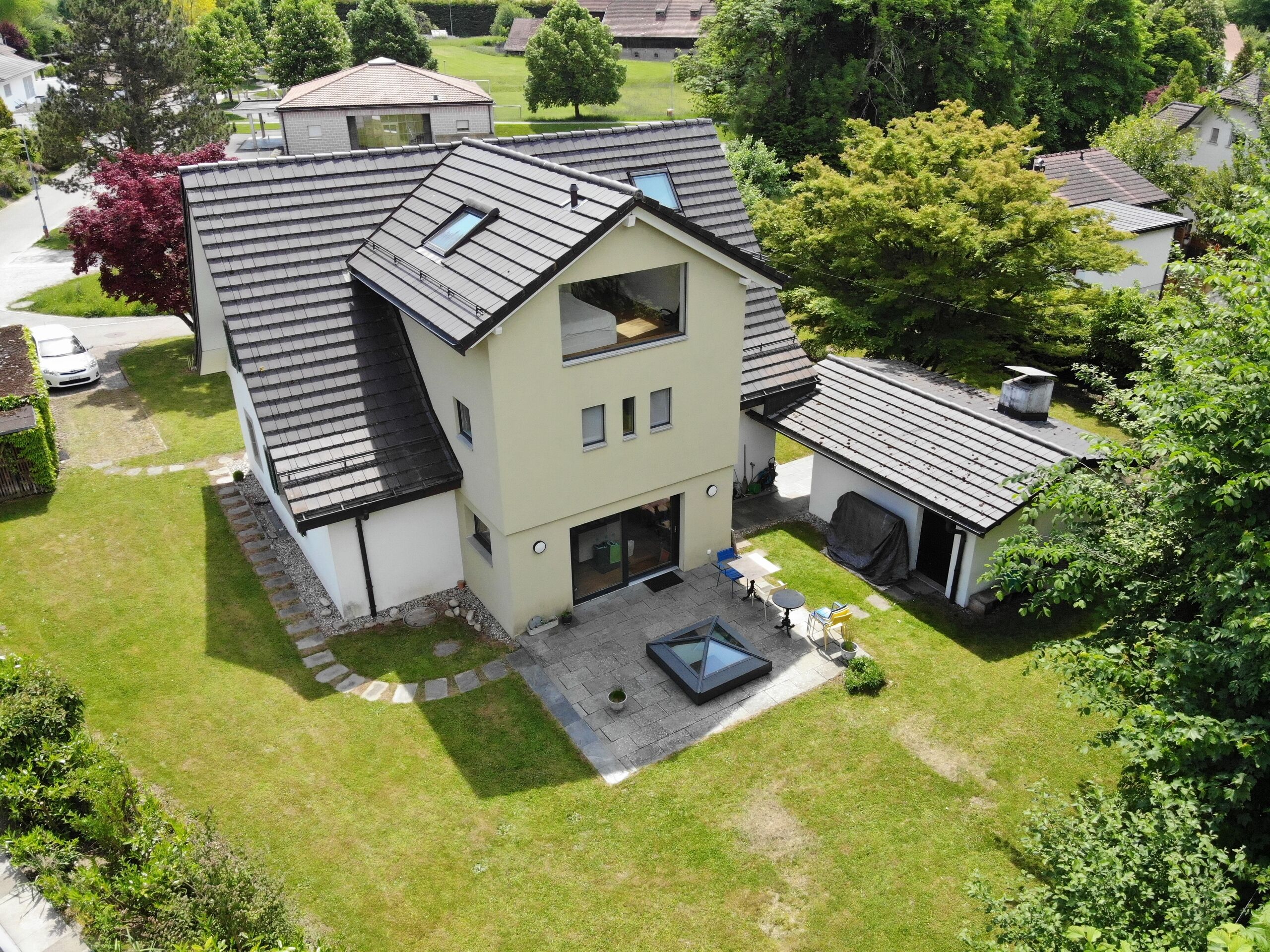 Luftaufnahme eines Einfamilienhauses mit Garten und Nebengebäude