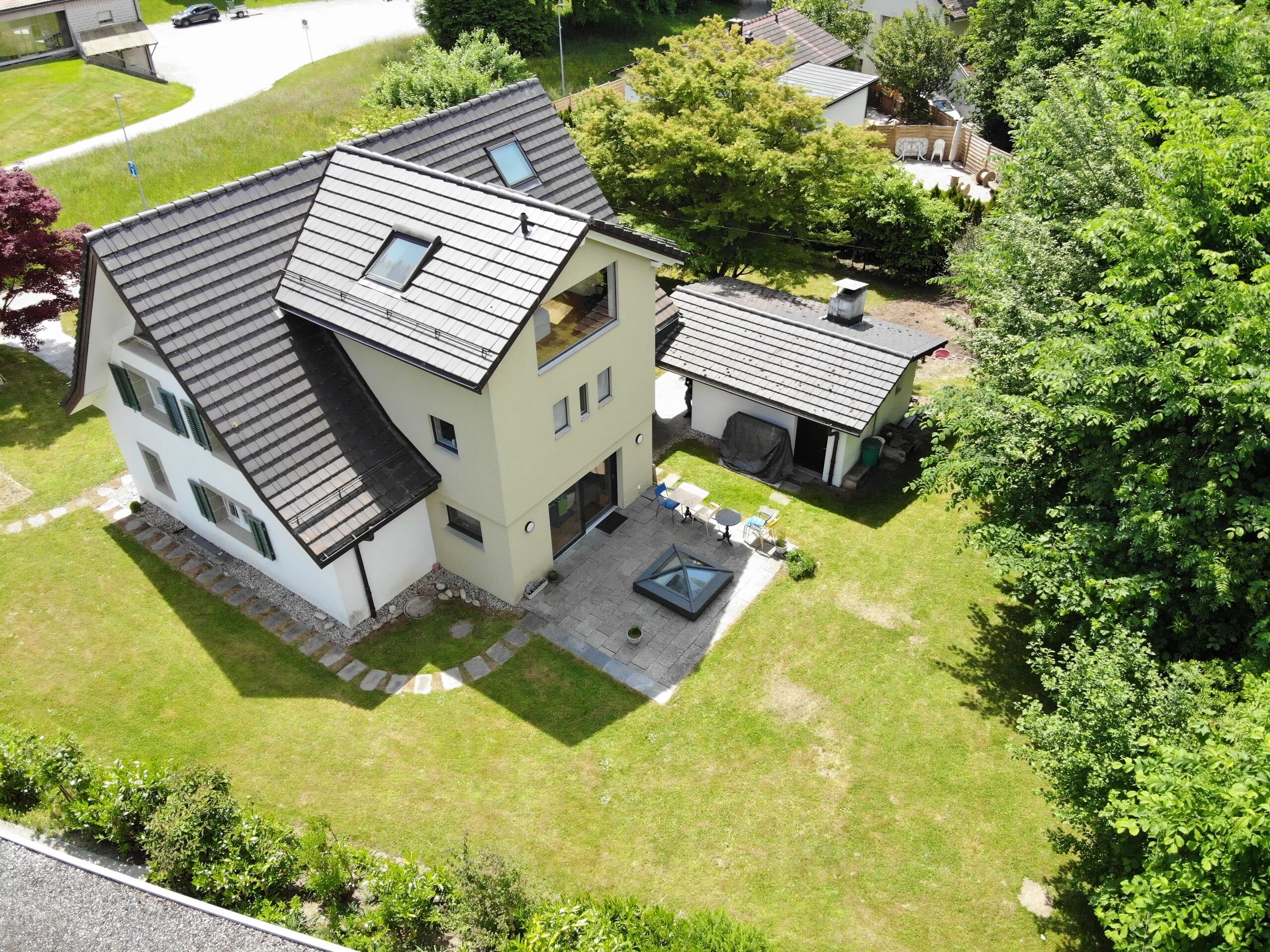 Drohnenaufnahme eines Einfamilienhauses mit großem Garten