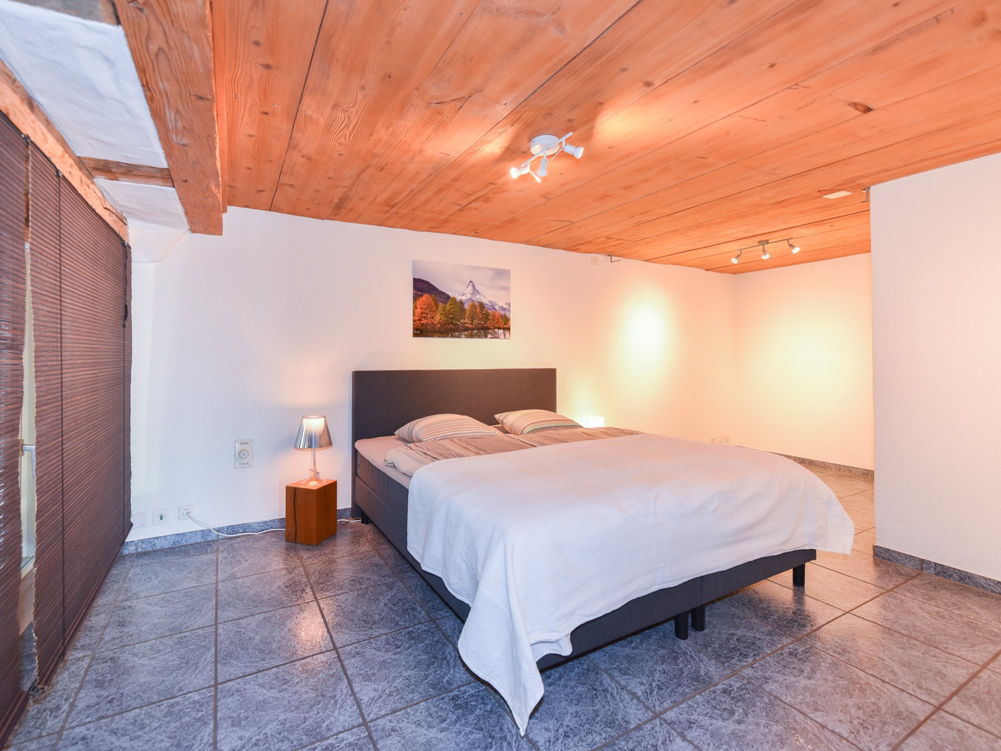 Schlafzimmer mit Holzdecke und gefliesten Böden
