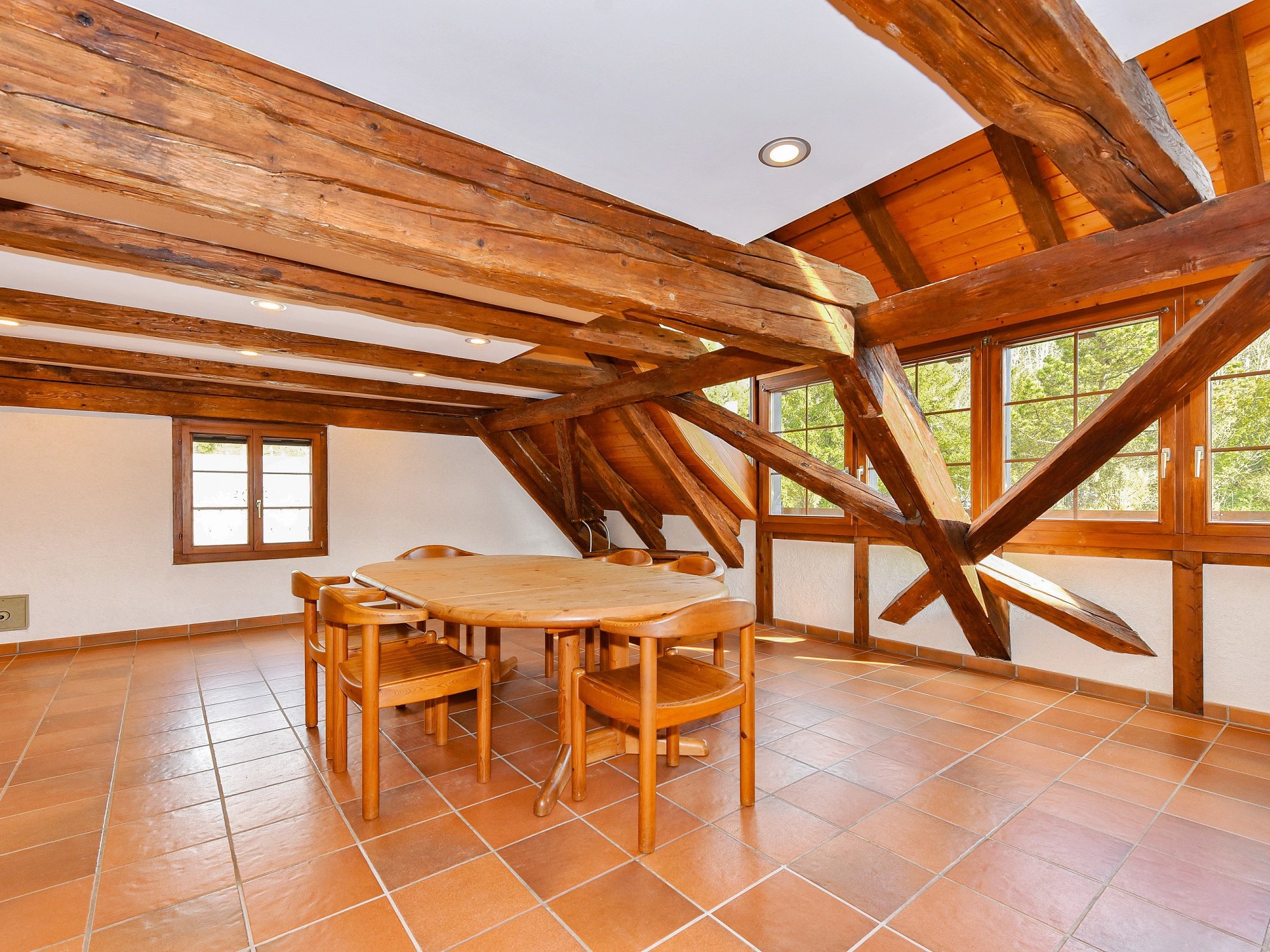 Rustikaler Dachraum mit Holzbalken und Terrakottafliesen