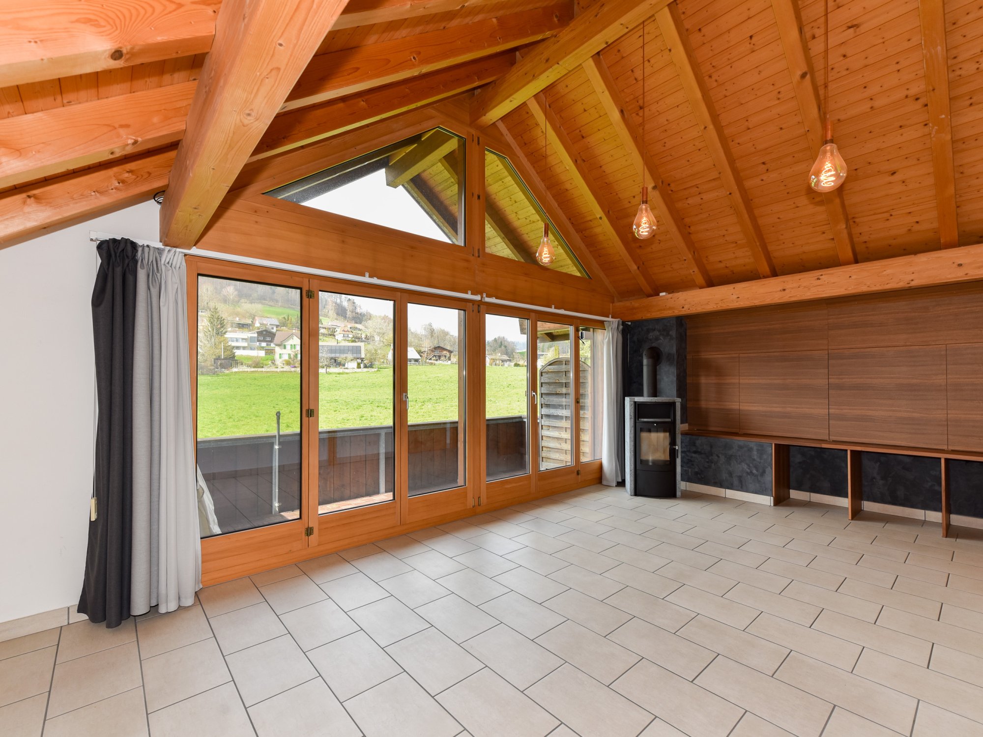 Heller Wohnraum mit Holzdecke und Kaminofen