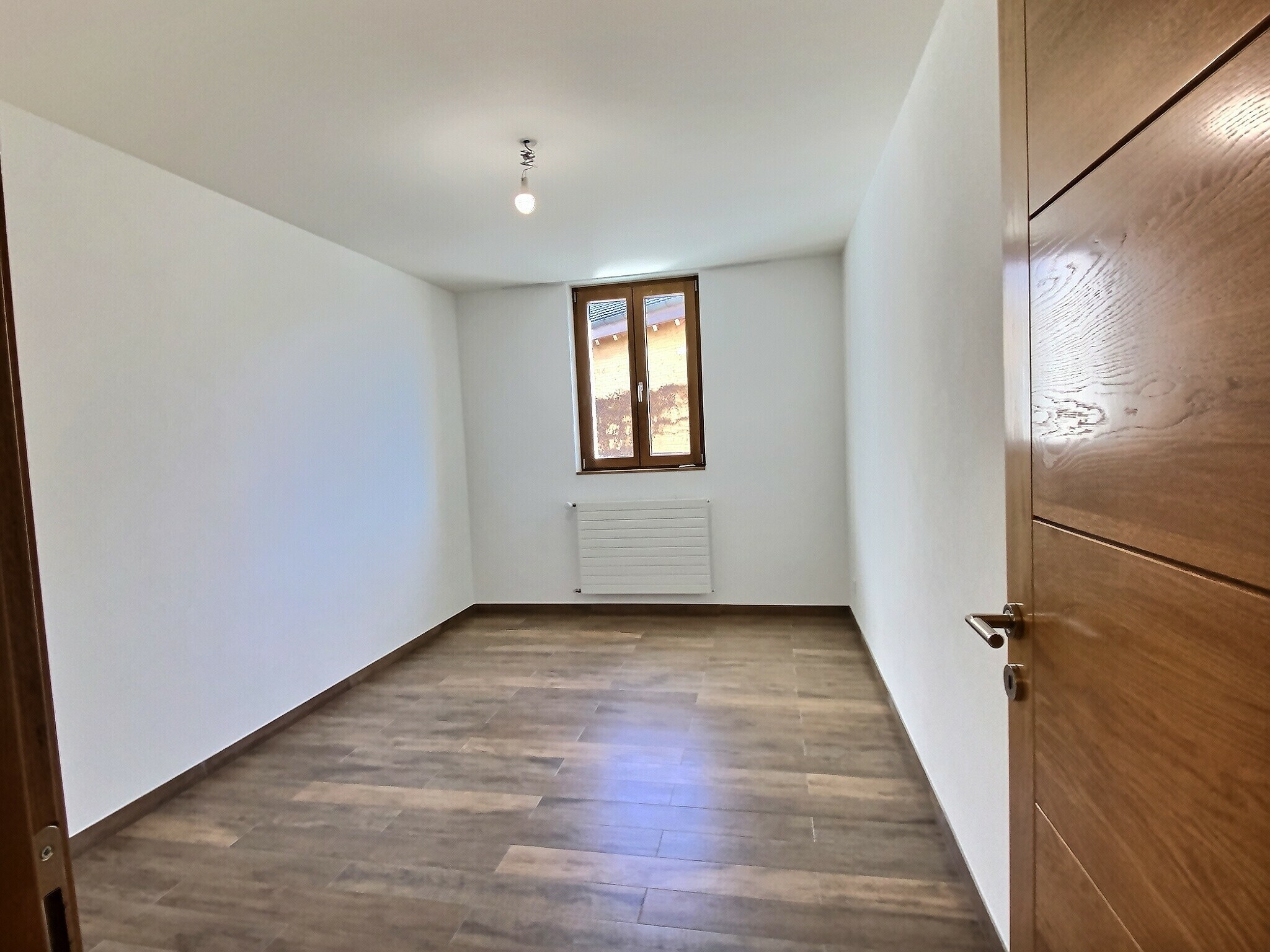 Leerer Raum mit Holzfenster und Heizkörper