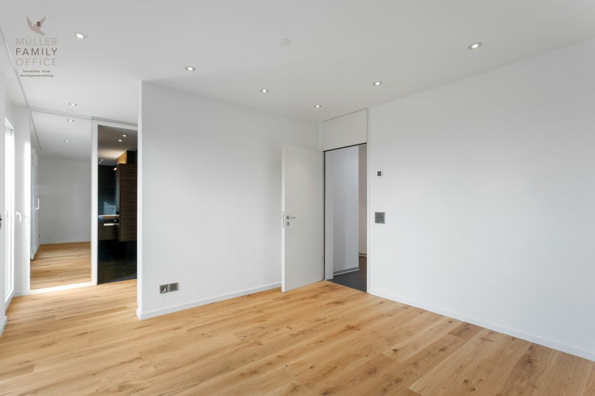 Helles, leer stehendes Schlafzimmer mit Holzboden
