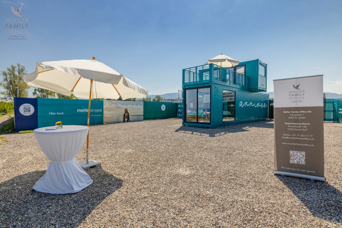 Temporäres Outdoor-Setup mit Container-Modul und Sonnenschirmen