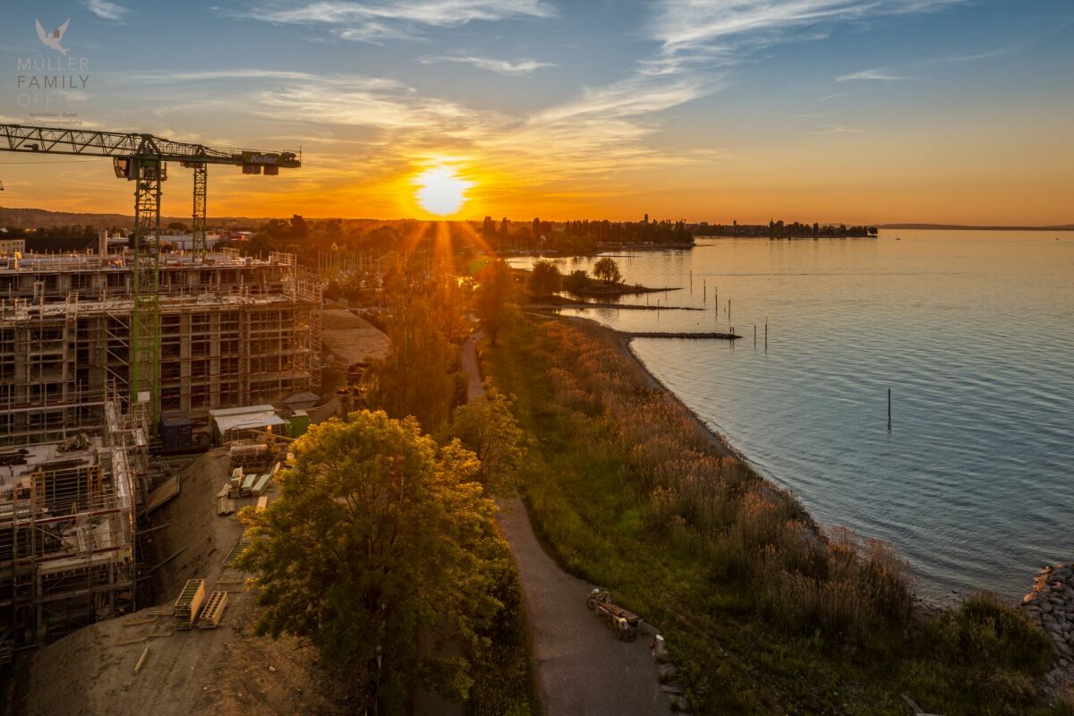 Seeblick bei Sonnenuntergang neben einer Baustelle