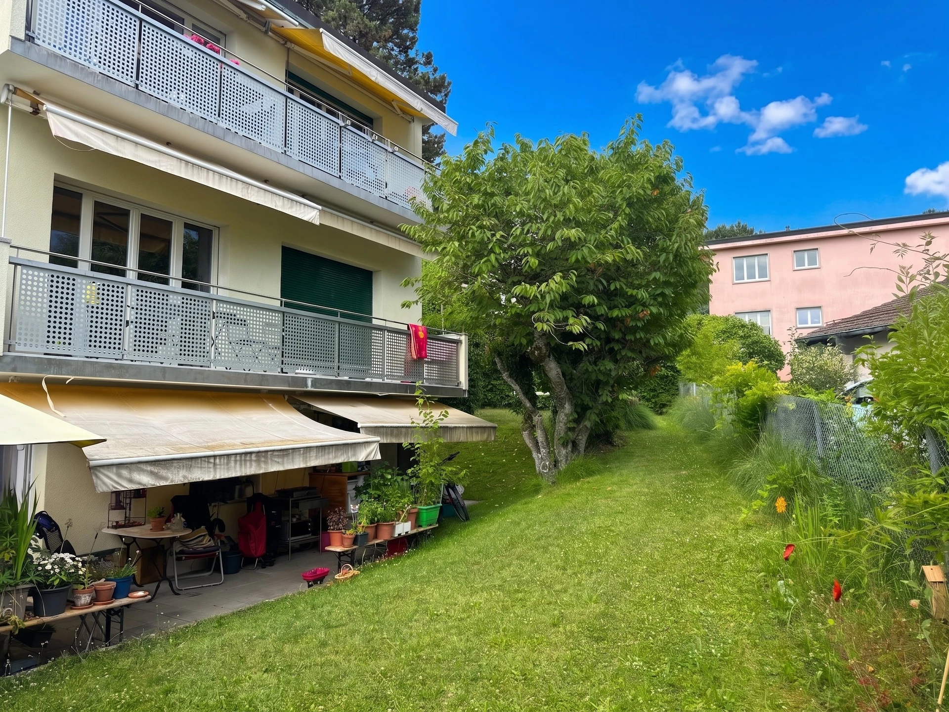 Gartenansicht eines Mehrfamilienhauses mit Balkon